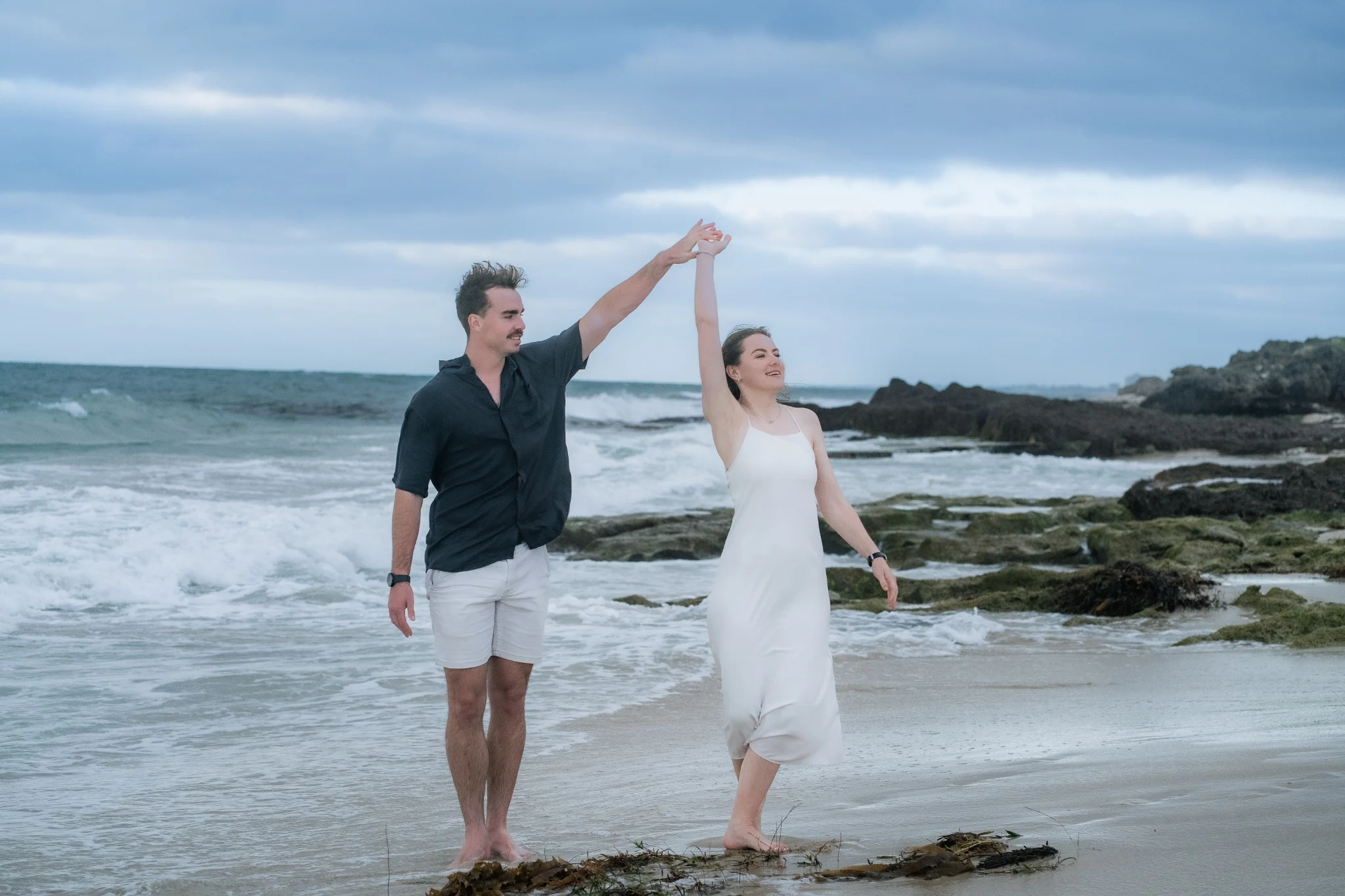 Marcja and Henrico dancing beside the sea during their Cottesloe engagement session