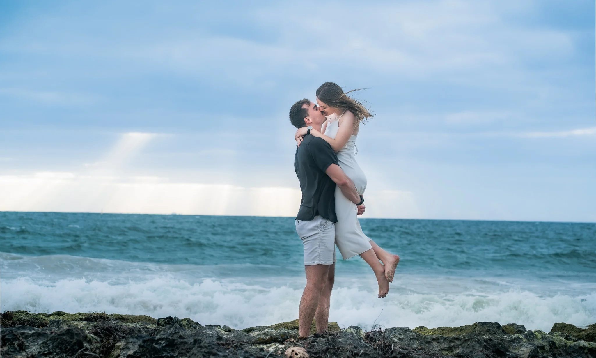 Henrico lifting Marcja beside the ocean at Cottesloe Beach
