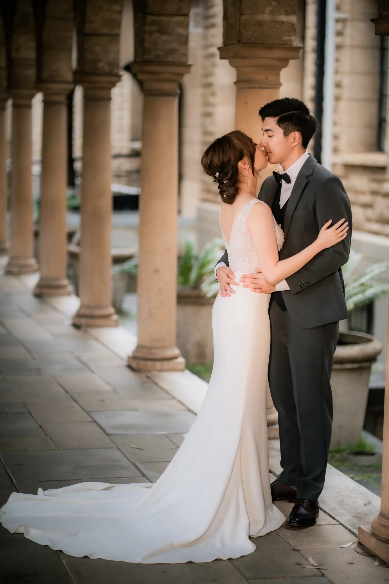 Melody and Ken kissing beneath the UWA colonnade in Perth, Western Australia